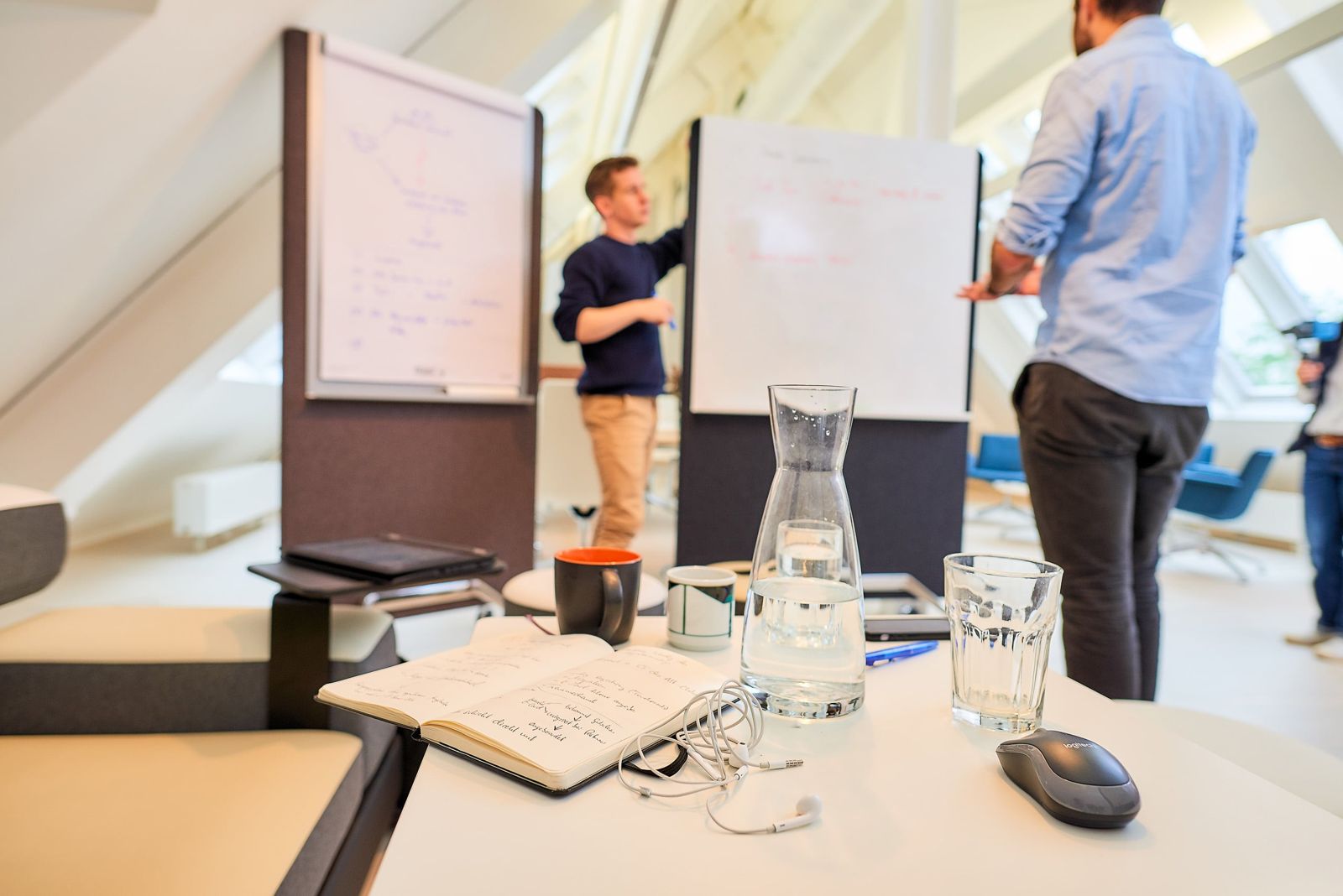 Arbeitsraum eines Workshops mit Flipcharts und Notizbuch